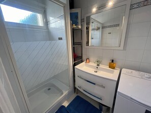 A bathroom with a glass shower enclosure, a white sink with a glass soap dish, and a mirror above the sink. - Air-conditioned apartment with sea view 50m from the sea in Sant Ambroggio (Lumio)