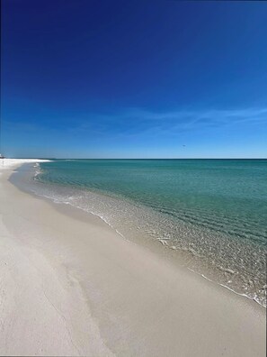 A beach with clear turquoise water and a long pier extending into the ocean. - Bright, Modern & Beach Front. Amazing gulf views! Beach Retreat @ Sterling Sands (Destin)
