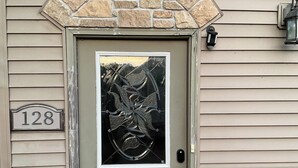 A house number 128, a gray door with a stone arch, and a stone wall. - 3 Bedroom, full kitchen and remodeled bathroom. Water-views from the Kitchen and covered deck. (Caseyville)