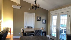A dining area with a large table, chairs, a chandelier, and a door with a view. - 3 Bedroom, full kitchen and remodeled bathroom. Water-views from the Kitchen and covered deck. (Caseyville)