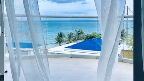 A balcony with a view of the ocean and palm trees. - OCEAN VIEW VILLA WITH PRIVATE POOL ,STEPS FROM SECLUDED BEACH, GATED COMMUNITY! (Yabucoa)