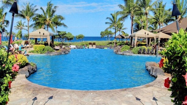 A resort pool with palm trees, lounge chairs, and a view of the ocean. - Klvr presents Honua Kai Resort K238*Quiet location (Lahaina)