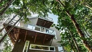 A multi-story building with a balcony and a window. - Treehouse, 3 bedrooms (4th bedroom, sleeps 7+), EV terminals. (Petite-Rivière-St-Francois)