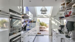 A modern kitchen with stainless steel appliances, a view to the outdoors, and a dining area with a view. - Waterfront house, large terrace and waterfront - Balcony on Arromanches (Asnelles)