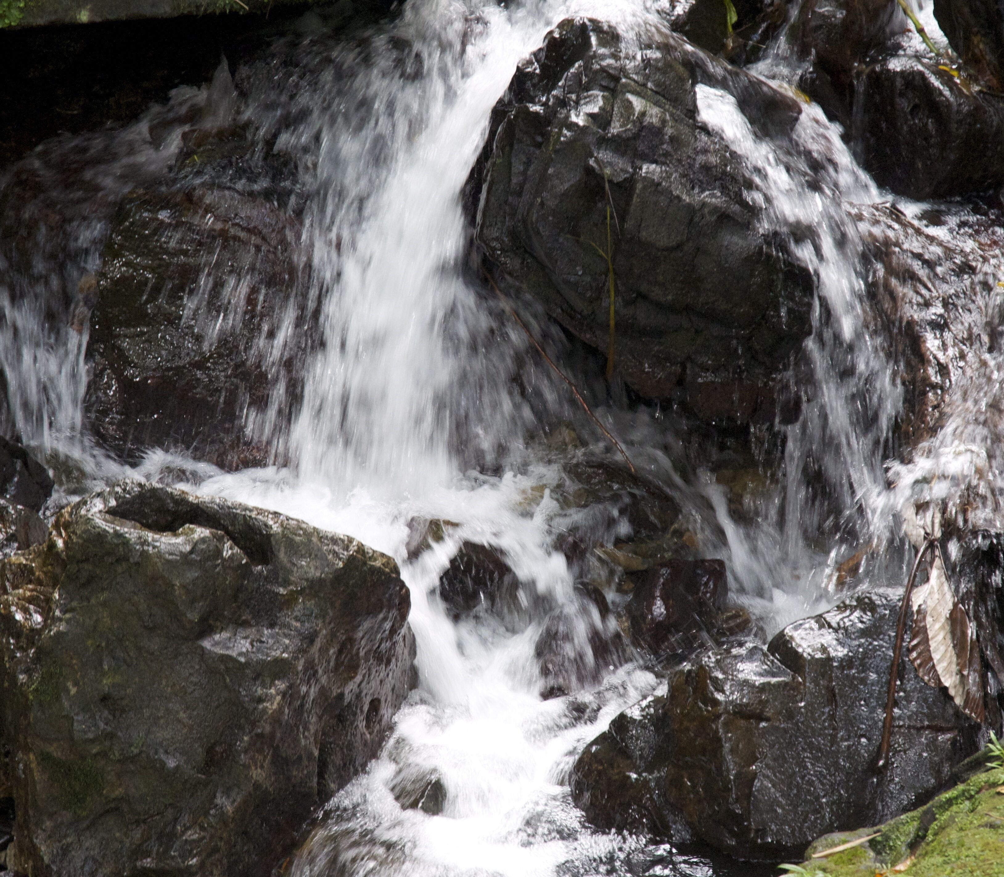 A waterfall cascading over rocks in a natural setting.