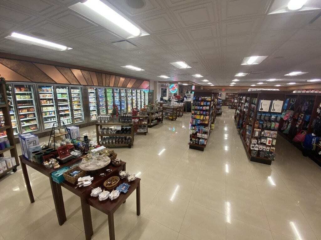 Een ruime winkel met brede gangpaden, gekoelde afdelingen en diverse productpresentaties.