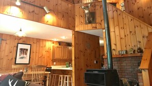 Un intérieur en bois avec une cheminée, des murs en bois et un coin repas.