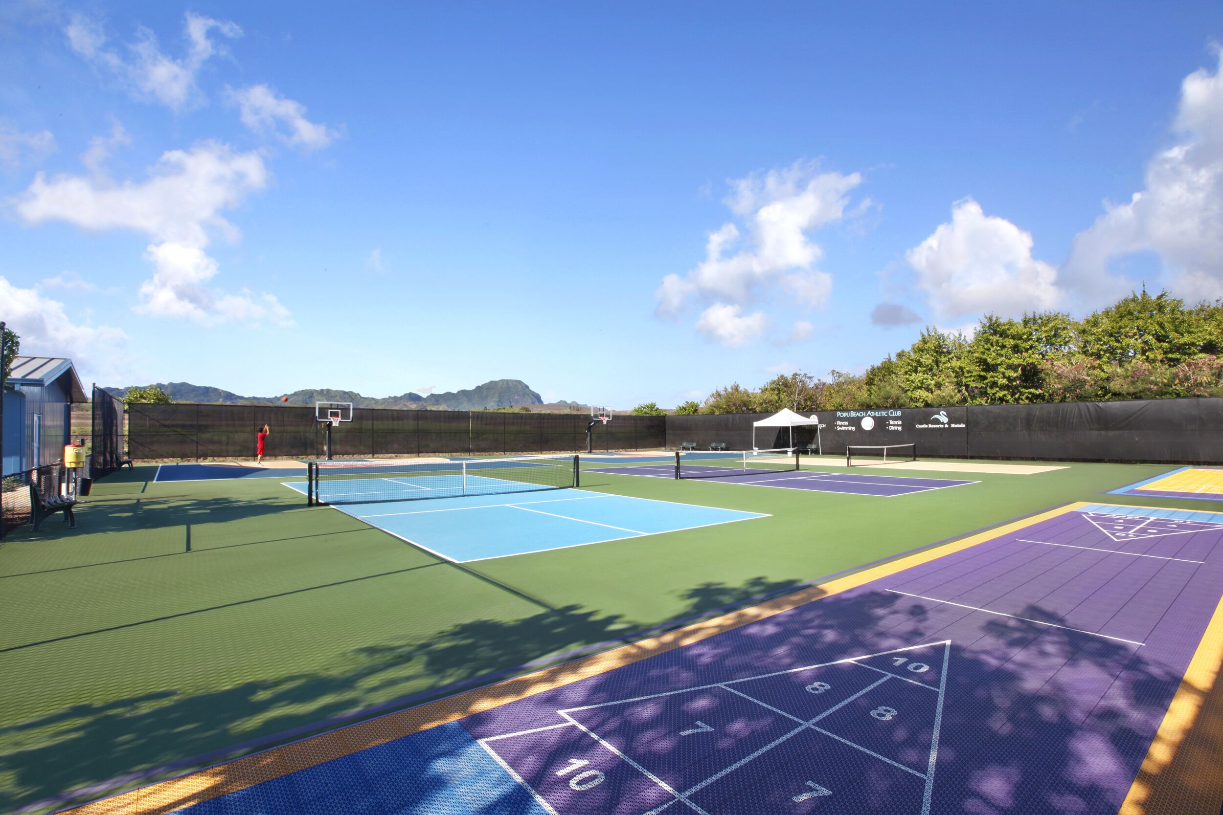 Canchas de tenis múltiples, un aro de baloncesto y un área para juego de rayuela.