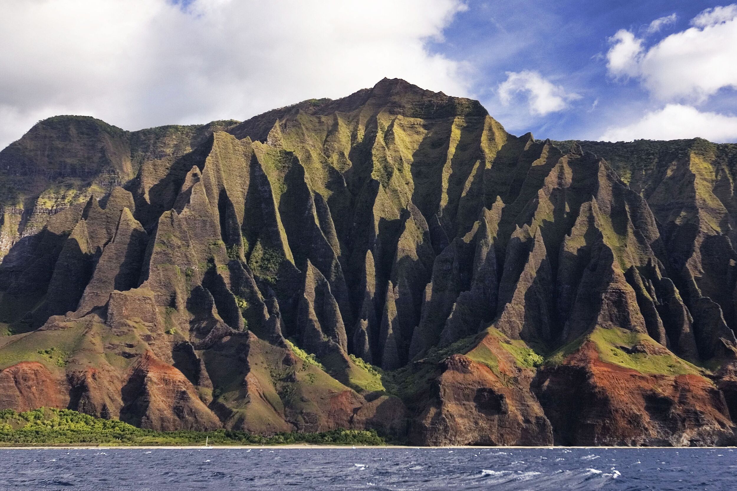 A mountain with steep cliffs and a clear sky.
