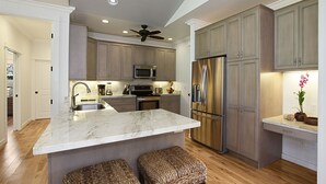 Una cocina moderna con una isla grande, electrodomésticos de acero inoxidable y suelo de madera.