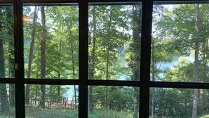 A room with large windows offering views of a forested area and a lake. - Year-round 3BR/2BA Lake front - Nolin State Park (1mile) -Mammoth Cave (30min) (Mammoth Cave)