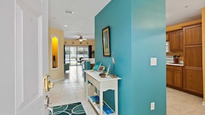 A modern kitchen with wooden cabinets, a white countertop, and a ceiling fan. - Villas of Ocean Gate #106 Ocean side 2 bedroom, pool view, pet friendly (St Augustine)