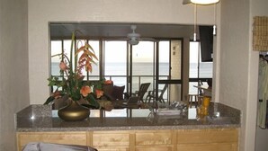Eine Küche mit Meerblick, einem Deckenventilator und einem großen Fenster.