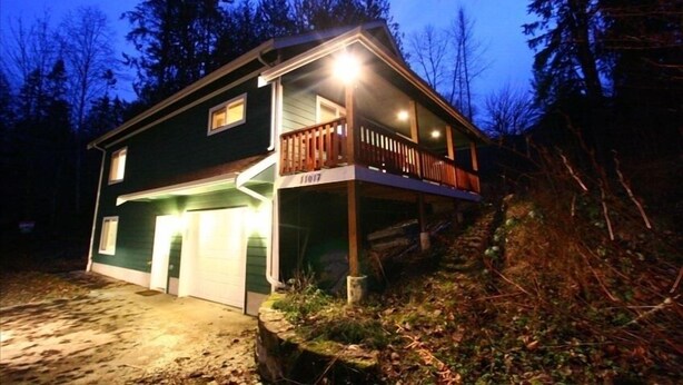Une maison à deux étages avec un porche couvert et un garage.