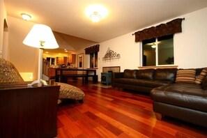 Relax in this inviting living room with a sofa, ottoman, and large window.