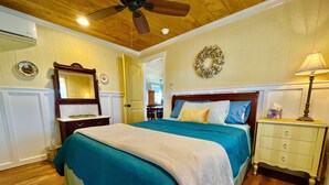 A bedroom with a bed, nightstand, dresser, and a ceiling fan. - Prime Location in Dripping Springs! Gorgeous Country Cottage for 10 by Camp Lucy (Dripping Springs)