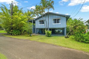 A two-story house with a covered porch and a small front yard.