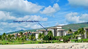 Ein Resort mit mehreren Gebäuden, einem Strand und Palmen.
