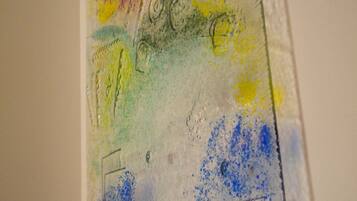 Een muur met een reliëf kunstwerk, abstract gevormd en kleurrijk.