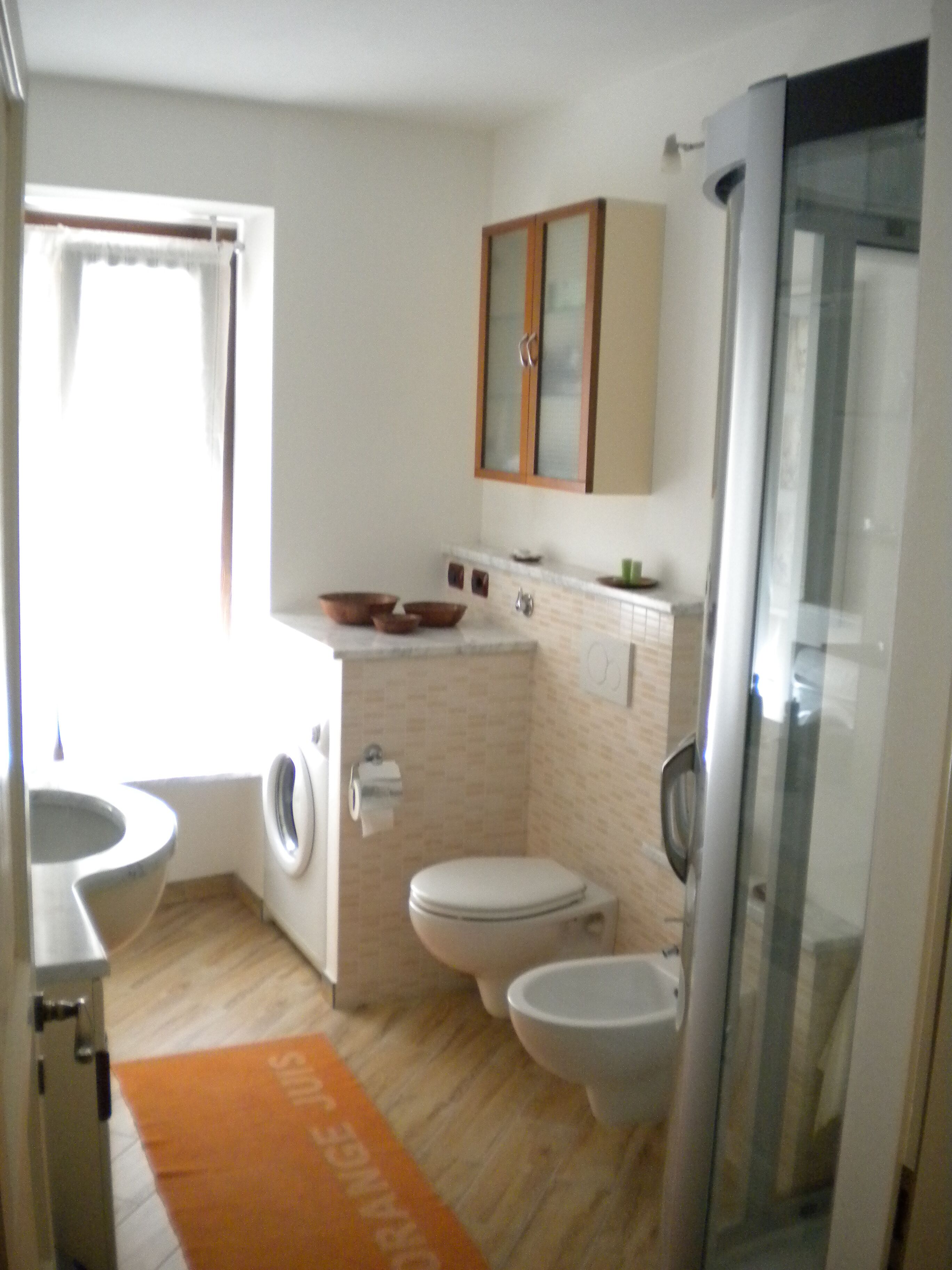 Un bagno compatto con toilette, bidet e lavatrice.
