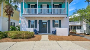 A two-story house with a balcony, a front door, and a small porch area. - Walk to a public beach! Walk to restaurants! True Owner Operator. (Santa Rosa Beach)