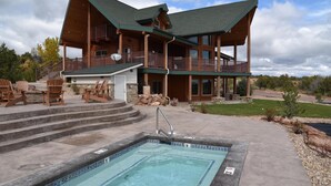 A two-story log cabin with a pool, outdoor seating, and a stone fireplace. - Beautiful Lake-side 5 Bedroom Lodge (Altamont)