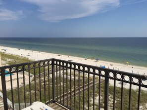 A beach view from a balcony with a railing, sandy beach, and ocean. - Legacy - Gulf Front Condo - Gulf Shores (Gulf Shores)