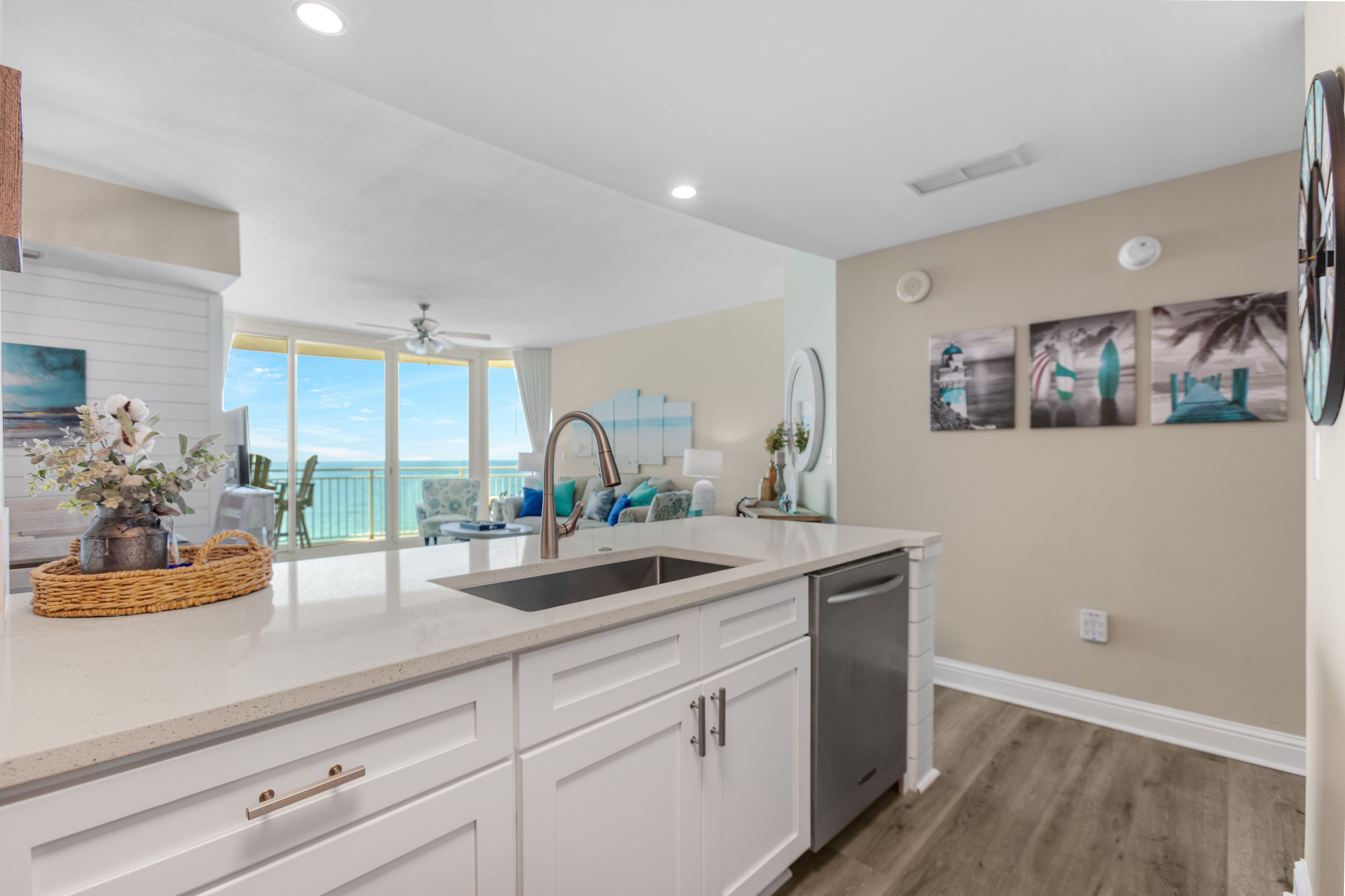 A modern kitchen with white cabinetry, a stainless steel sink, and a view to the outside.