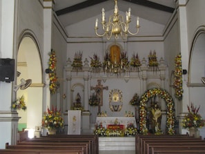 Stunning church interior with a high ceiling, chandelier, and ornate altar.