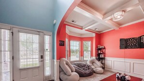 A room with a red and blue color scheme, a large bean bag chair, a Monopoly board game, and a dartboard. - Year round rental 4 miles from the Augusta National pool Hot tub Gym tanning bed (North Augusta)