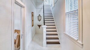 A staircase with white balusters and dark steps leading to a landing. - HISTORIC HOME - Walk to French Quarter - Free Parking - Sleeps 10 (New Orleans)