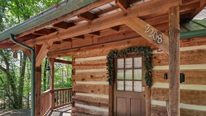 A wooden cabin with a porch, a door with a wreath, and the number 2208 on the wall. - Matthew11:28~4 mil Pkwy-Dwntwn Pigfrge hot tub, wifi-gas fireplace-NO EXTRA FEES (Pigeon Forge)
