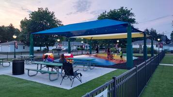 Relax in a covered seating area surrounded by trees and a playground for kids.
