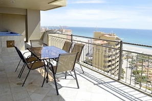 A balcony with a table and chairs, overlooking a beach and cityscape. - Bella Sirena 3 room Penthouse with Amazing views (Puerto Peñasco)