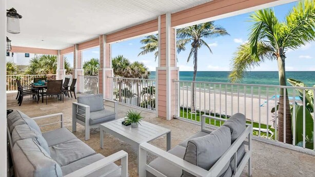 A covered outdoor seating area with a view of the beach and ocean. - Ocean Sands 4BR Beachfront Home in Indian Rocks (Indian Rocks Beach)