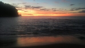 A sunset over a body of water with a distant landmass on the left. - Beachfront, Private Pool, Pure Luxury at  Bahia Pez Vela, Villa Las Olas #4 (Playa Ocotal)