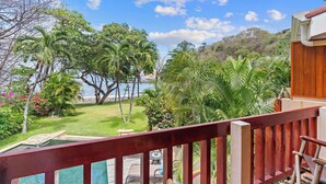 A balcony with a view of a lush garden and a body of water. - Beachfront, Private Pool, Pure Luxury at  Bahia Pez Vela, Villa Las Olas #4 (Playa Ocotal)
