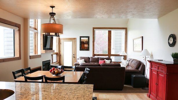 A spacious living area with a dining table, a sofa, and a red cabinet. - 4 BR/4 BA Townhome - Spacious, comfortable, the perfect getaway! (Park City)