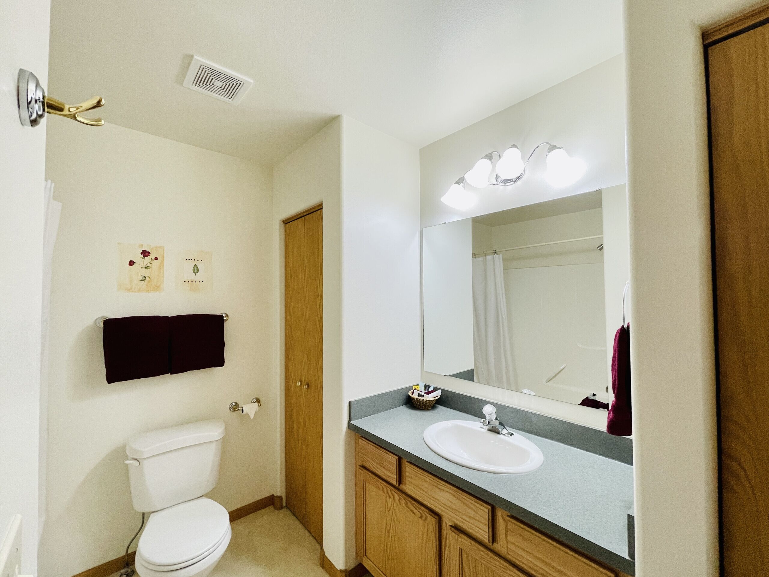 A bathroom with a toilet, sink, and mirror.