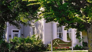 Een bord met 'Rosemont Guest Cottages' en een telefoonnummer.