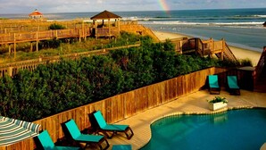 A beachside pool area with lounge chairs and a wooden deck overlooking the ocean. - Oceanfront & Soundfront! Luxury Beachfront, Pool, Private Exclusive West End   (Ocean Isle Beach)