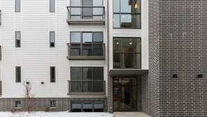 Un edificio de varios pisos con fachada blanca y sección de ladrillo.