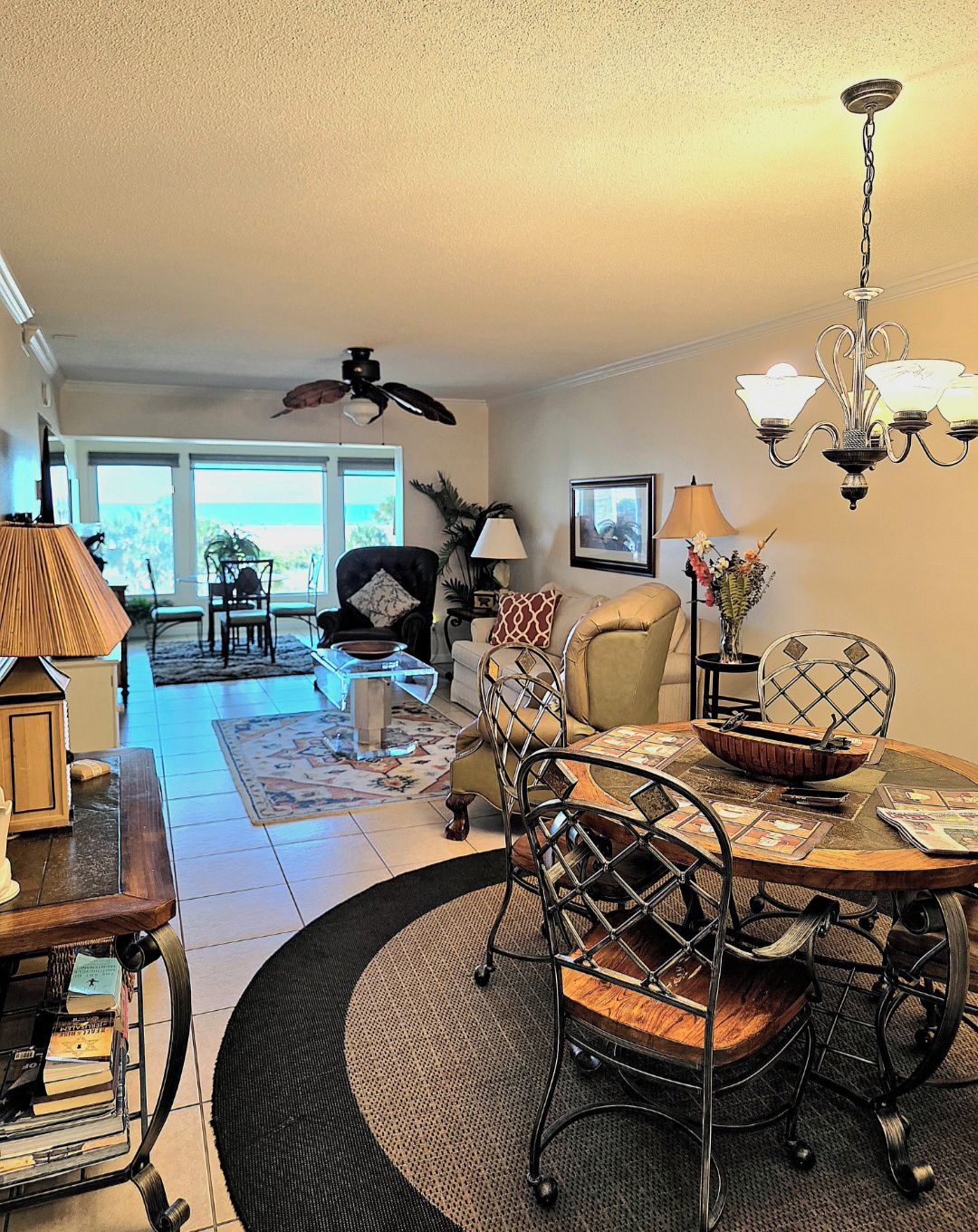 A dining area with a round table, chairs, and a chandelier.