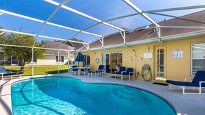 Ein überdachter Swimmingpool mit Liegestühlen und einem Schlauch zum Befüllen.