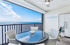 Private beachfront lanai with super screen, dining for four and lounger.