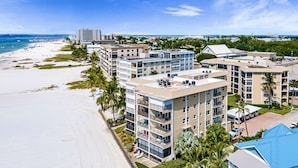 A beachfront hotel with multiple buildings, balconies, and a sandy beach. - On the Sand! Beachfront Pool & Views! Walk to Everything! (Fort Myers Beach)
