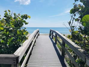 A wooden boardwalk leading to a beach with clear skies. - Island Oasis - Luxury Pool Home Steps to the Beach (Melbourne Beach)