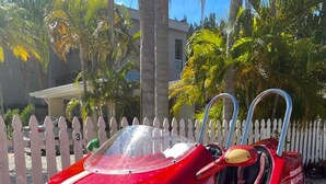 A red car with a white stripe and a steering wheel.