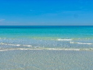 Una playa con agua turquesa cristalina y olas suaves.