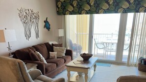A living room with a brown sofa, a grey armchair, and a coffee table. - It’s Beachy Keen!         (New Smyrna Beach)